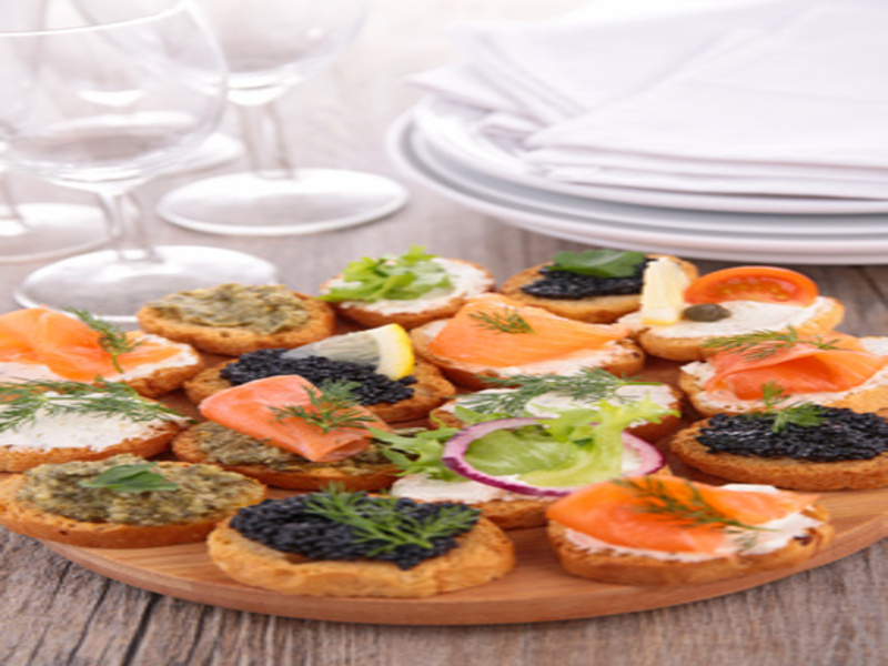 Canapes von geröstetem Baguette mit Weichkäse, Kaviar, Lachs und ...